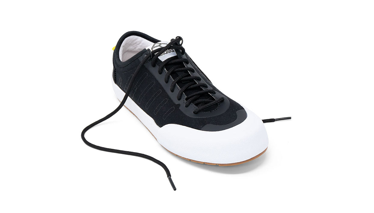 Landed The Overlook 1.0 technical sneaker in black with a white rubber toe cap and gum sole for everyday wear.