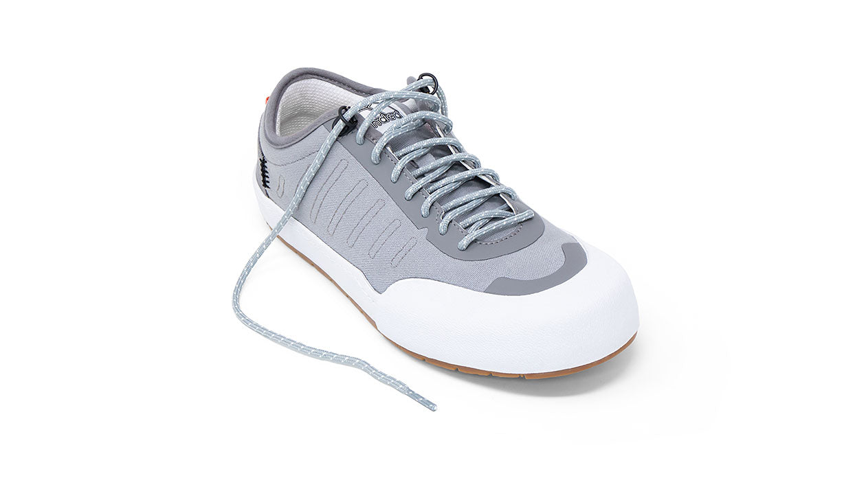 Landed The Overlook 1.0 technical sneaker in grey and white with a gum rubber sole and reflective laces.
