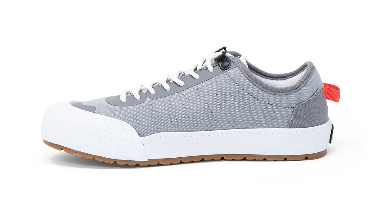 Landed The Overlook 1.0 grey technical sneaker with white rubber toe cap and gum sole, side profile view.