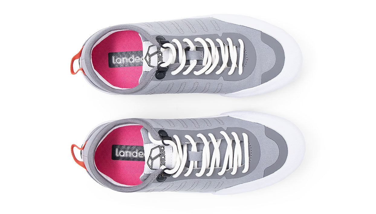 Landed The Overlook 1.0 grey technical sneakers with white laces and vibrant pink insoles, top-down view.