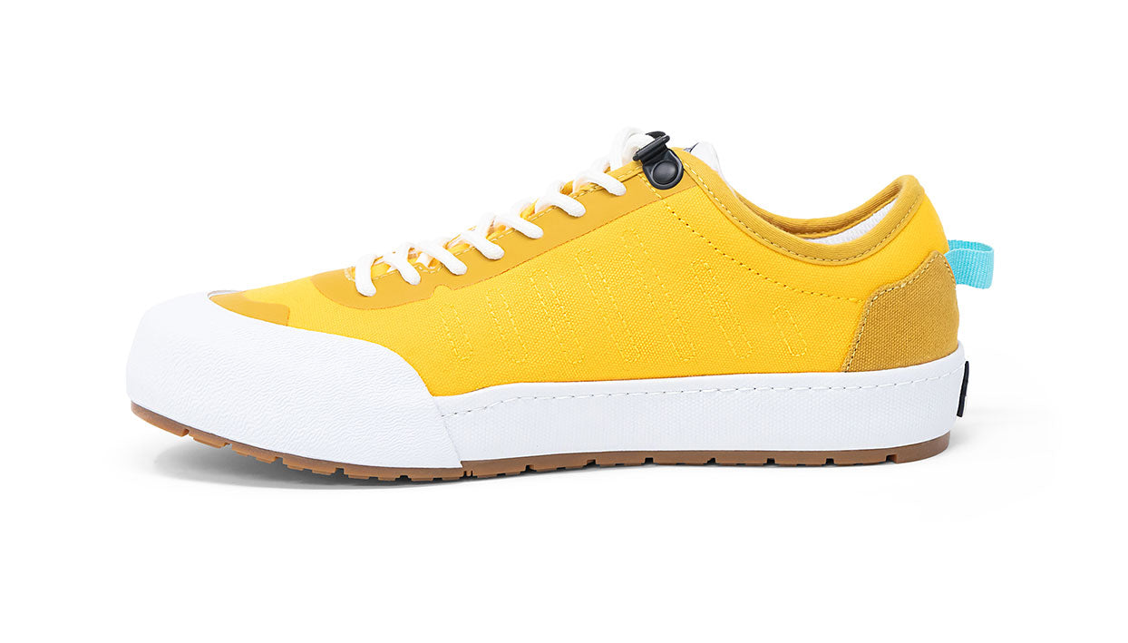 Landed The Overlook 1.0 yellow technical sneaker with white rubber toe cap and gum sole in a side profile view