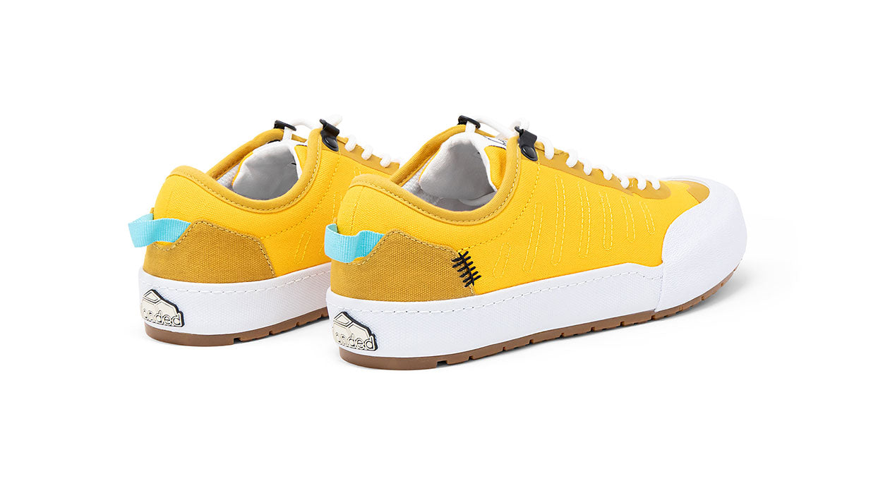 Landed The Overlook 1.0 yellow technical sneakers with white rubber soles and light blue heel pull tabs