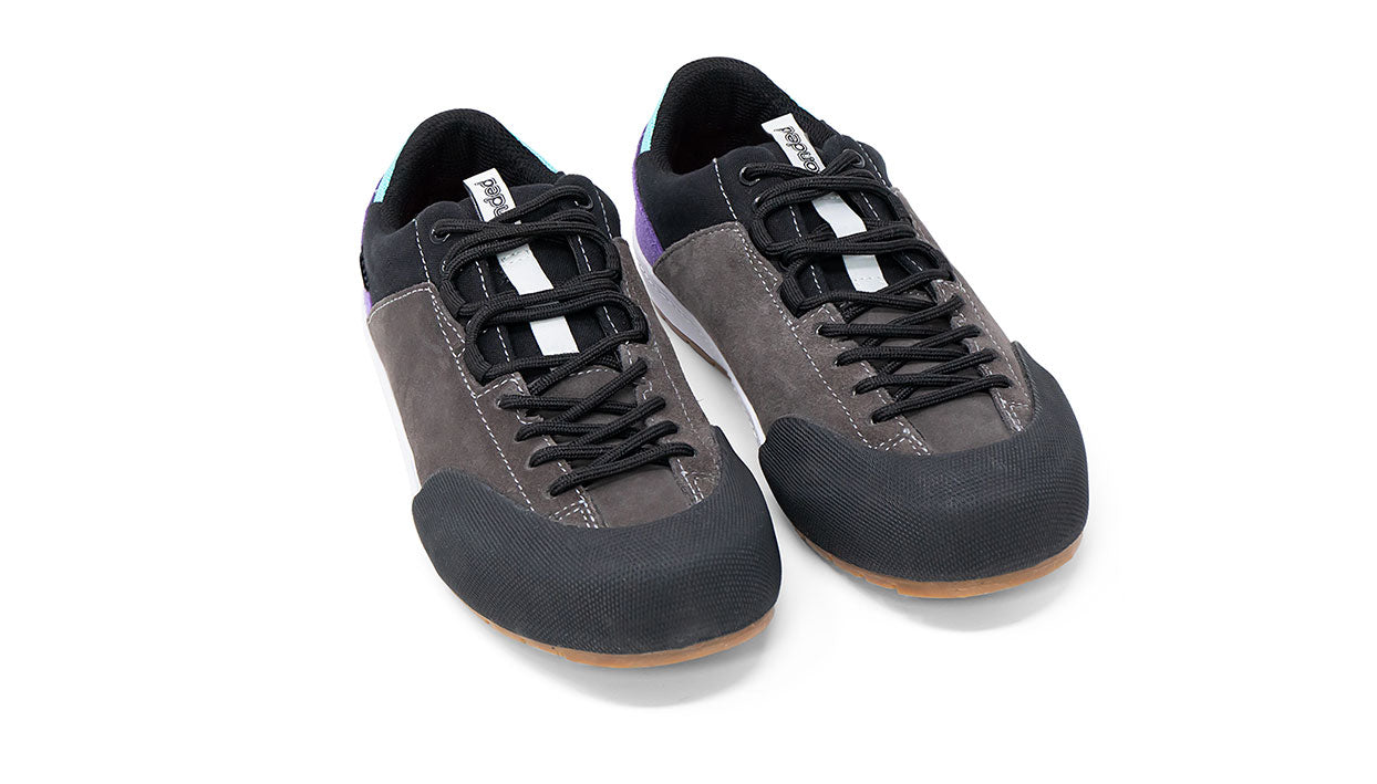 Landed The Switchback approach shoes in grey suede with black rubber toe caps and purple and blue heel accents.