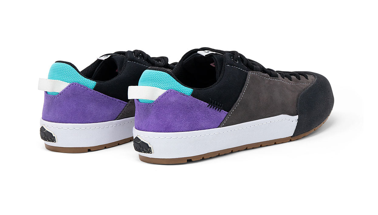 Landed The Switchback sneakers featuring black, grey, and purple suede panels with a teal heel tab and gum sole.