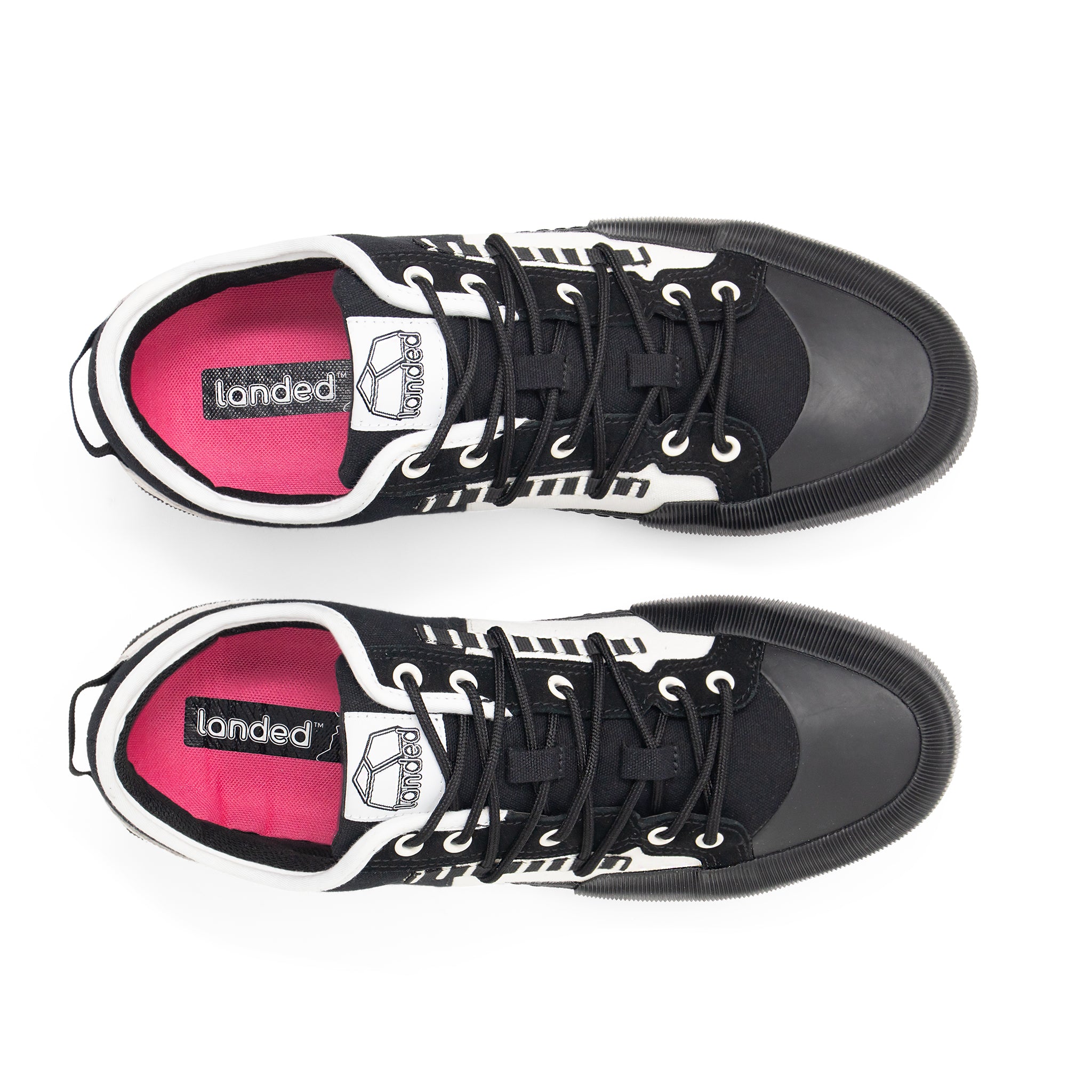 Landed The Banner sneakers in black and white with a vibrant pink insole, viewed from directly above.