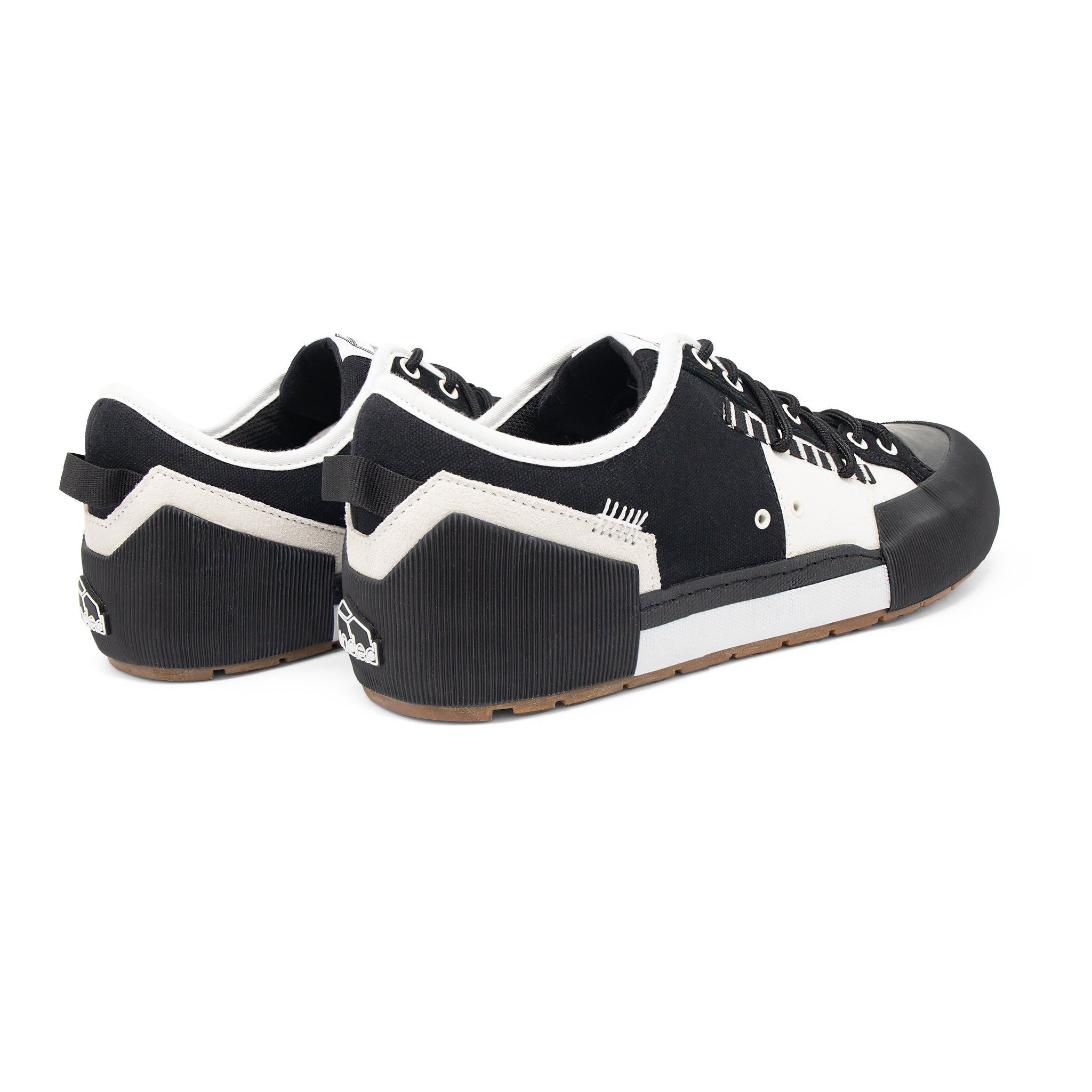 Landed The Banner sneakers in black and white with a technical silhouette, rubberized heel, and contrast stitching.