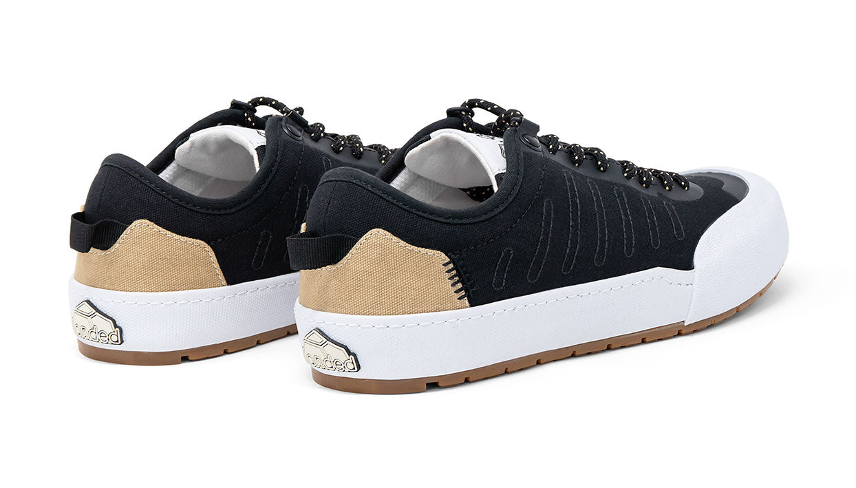 Landed The Overlook 1.0 technical sneakers in black and tan with white midsoles and gum rubber outsoles, rear view.